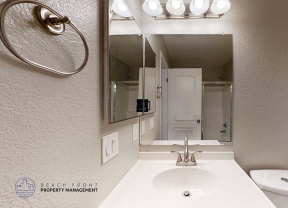 A bathroom with a white sink and toilet.