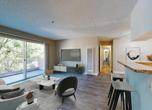 A modern living room with a large window and a flat screen TV.