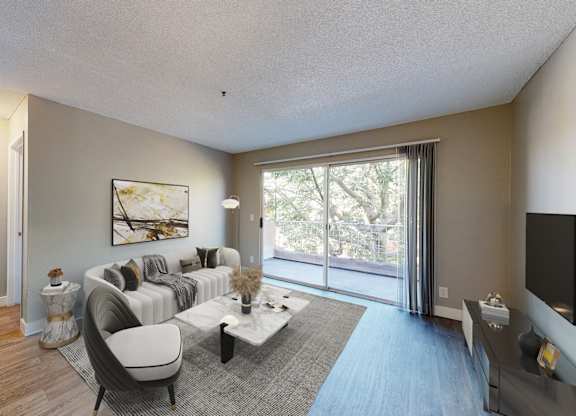 A living room with a grey couch and a painting on the wall.