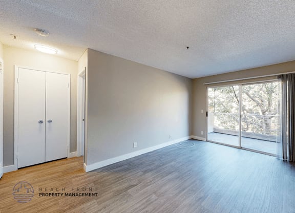 A room with a sliding glass door leading to a balcony.