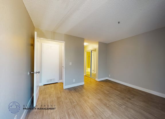 A room with wooden floors and two doors.