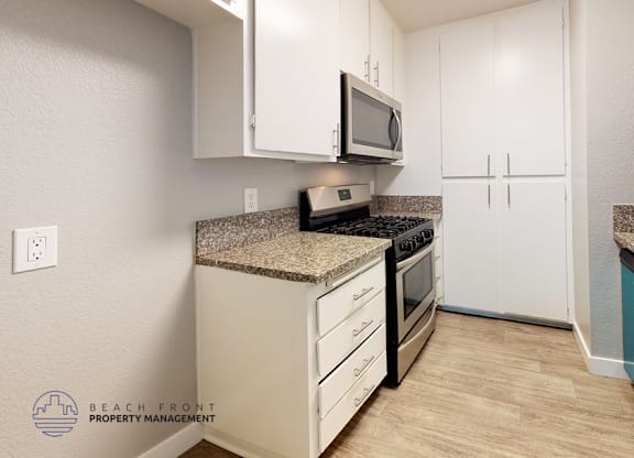 A kitchen with a granite countertop and white cabinets.