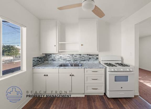 A room with wooden flooring and a logo for Beach Front Property Management.