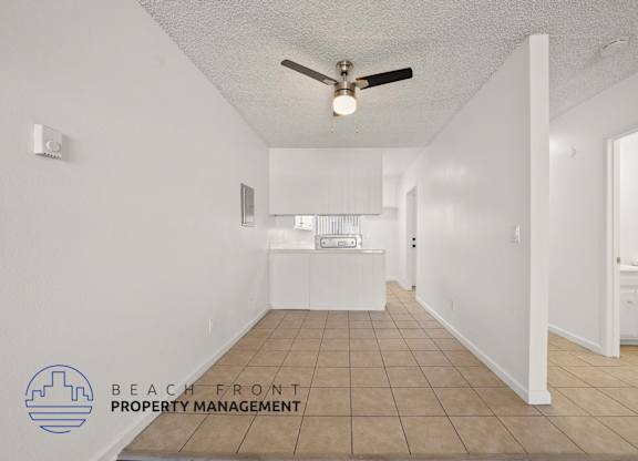 A spacious room with a ceiling fan and tiled floor.