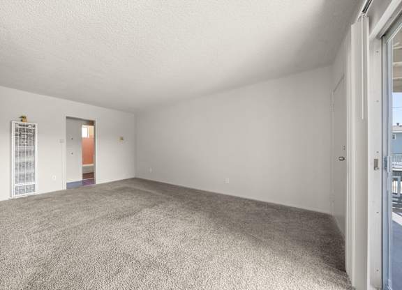 A room with a grey carpet and white walls.