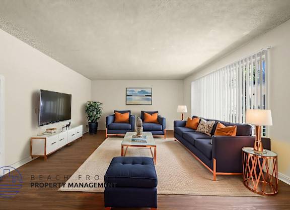A living room with a dark blue sofa and a wooden coffee table.