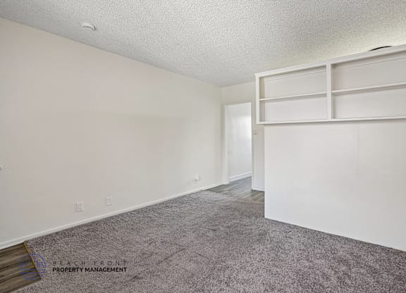 A room with a grey carpet and white walls.