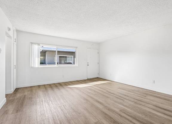 A room with wooden flooring and a window.