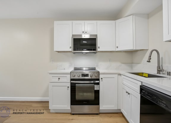 A kitchen with white cabinets and appliances.