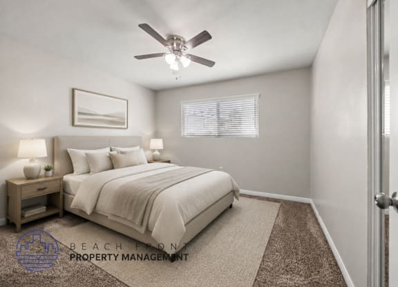 A well-lit bedroom with a large bed and a ceiling fan.