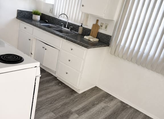 A kitchen with white cabinets and a black stove top.