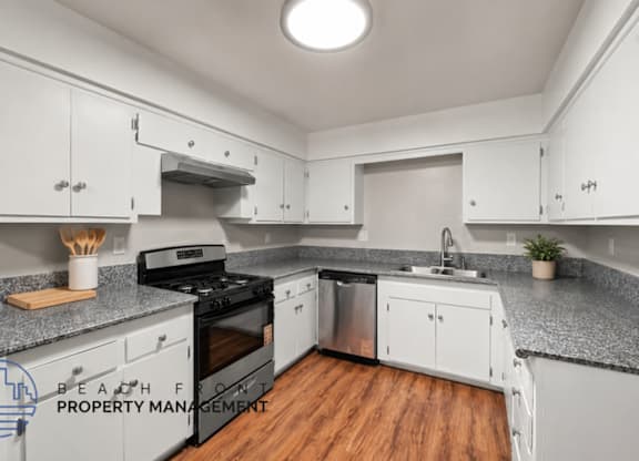 A kitchen with white cabinets and a black stove top oven.