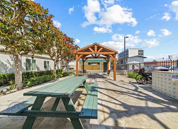 a picnic area with benches and a wooden pavilion