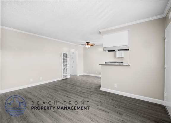 a living room with a kitchen and a ceiling fan