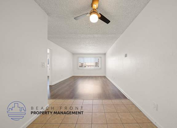 A room with a ceiling fan and tiled floor.