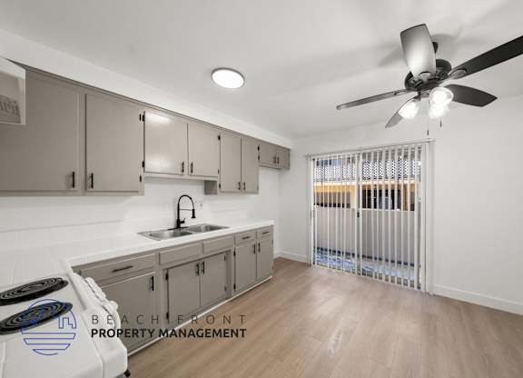 A kitchen with a fan and a sink.