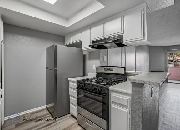 A modern kitchen with stainless steel appliances and white cabinets.