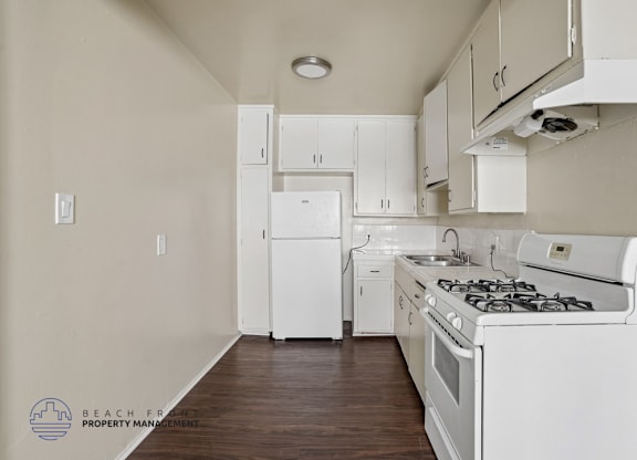 A kitchen with white appliances and cabinets.