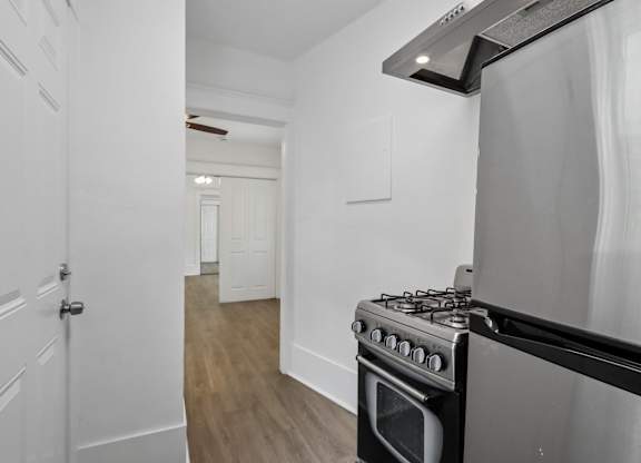 A stainless steel oven in a kitchen with white walls.