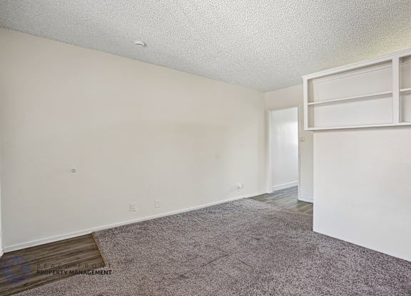A room with a carpeted floor and white walls.