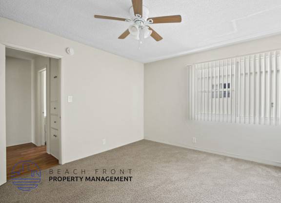 A room with a ceiling fan and a radiator on the wall.
