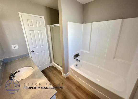 a bathroom with a white tub and a sink and a mirror