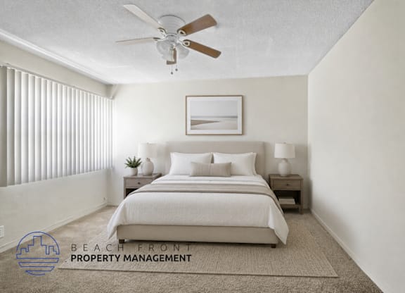 A bedroom with a bed, nightstands, and a ceiling fan.
