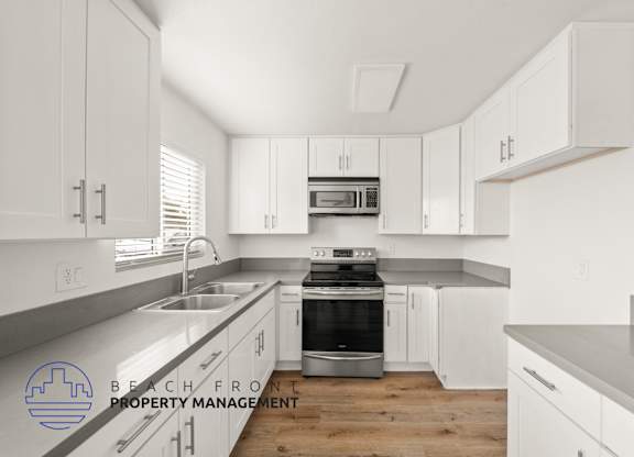A kitchen with white cabinets and a stainless steel oven.