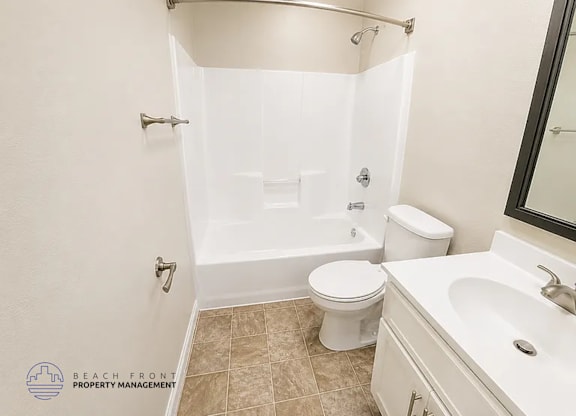 A bathroom with a toilet, sink, and shower.