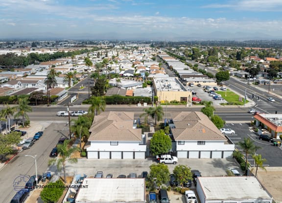 A bird's eye view of a parking lot with a building in the center.