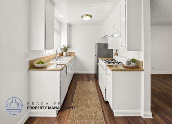 A kitchen with white cabinets and a brown rug on the floor.