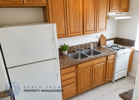 A kitchen with wooden cabinets and a white refrigerator.