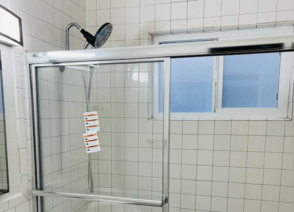A white bathroom with a sink, toilet, and shower.