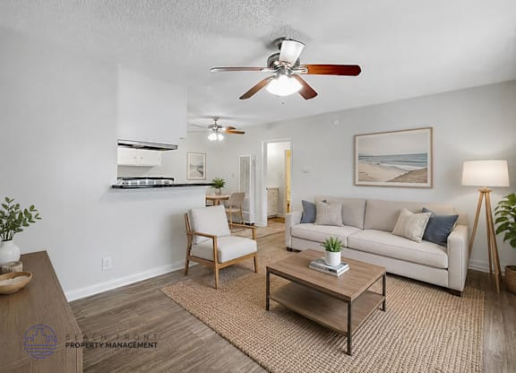 A living room with a ceiling fan, a couch, a chair, and a coffee table.