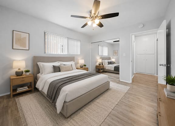 A bedroom with a large bed and a ceiling fan.