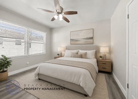 A well-lit bedroom with a large bed and a ceiling fan.