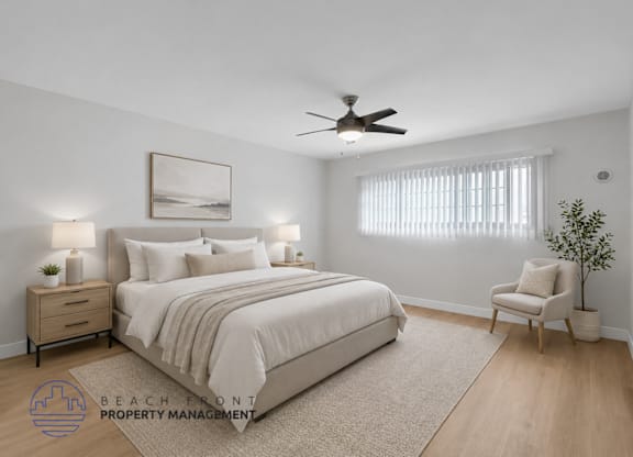 A well-lit bedroom with a large bed, a chair, and a ceiling fan.