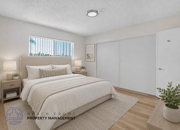 A bedroom with a large bed, a nightstand with lamps, a window with blinds, a rug, a potted plant, and a sliding door.