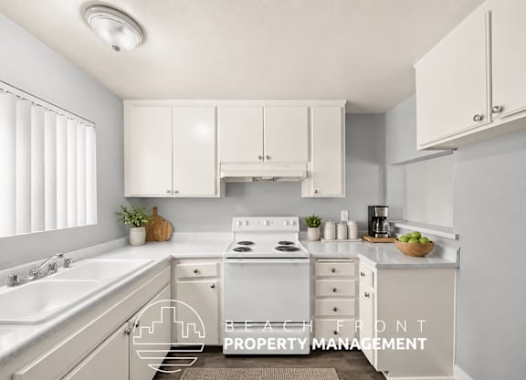 A kitchen with white cabinets and a stove top oven.