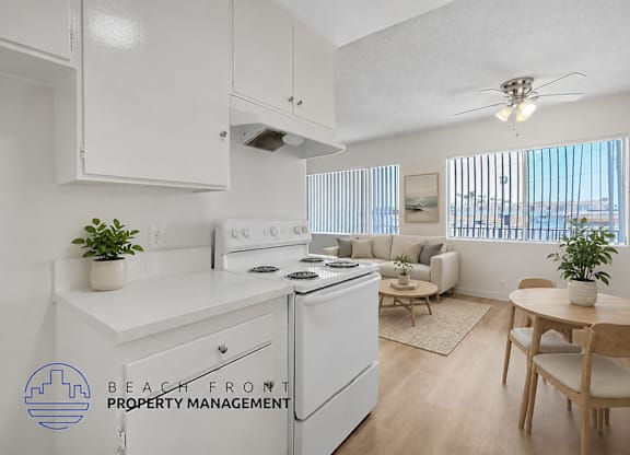 A kitchen with white appliances and a dining table with chairs.