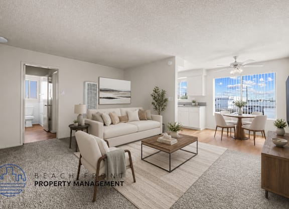 A living room with a white couch, a coffee table, and a dining table with chairs.