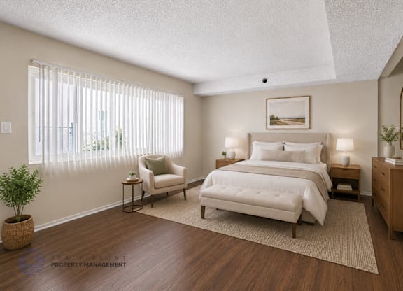 A well-lit bedroom with a large bed and a chair.