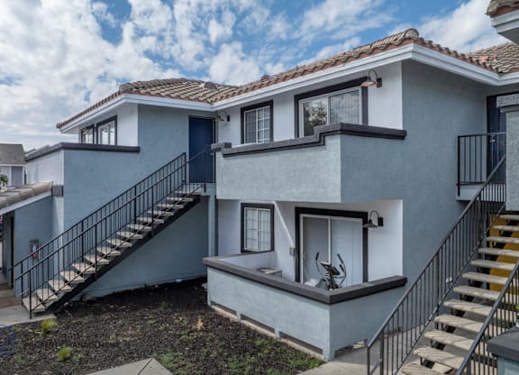 A modern two-story house with a balcony on the second floor.
