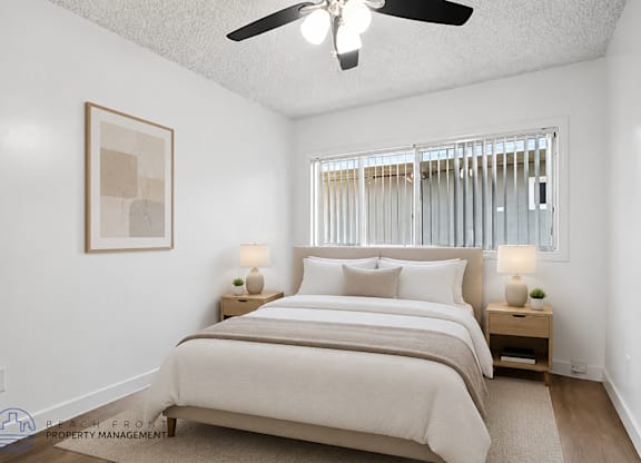 A bedroom with a large bed and a ceiling fan.