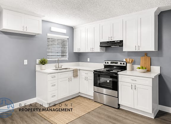 A kitchen with white cabinets and a stainless steel stove.
