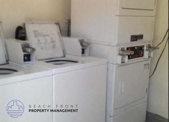 A white washing machine sits next to a white dryer.