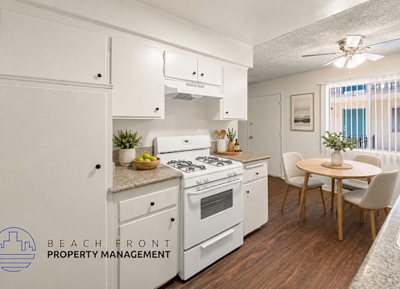 A kitchen with white appliances and wooden floors.