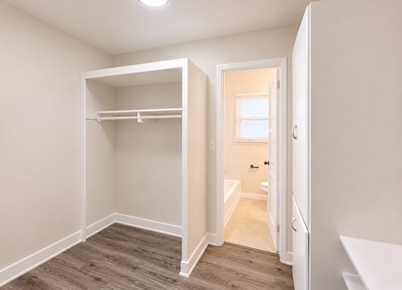 A small bedroom with a bunk bed and a doorway leading to another room.