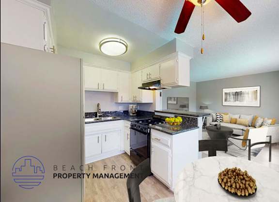 A kitchen with a fan and a dining table with chairs.