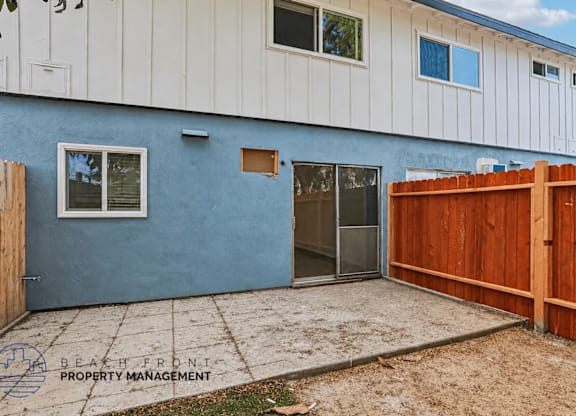 A blue and white building with a wooden fence in front.